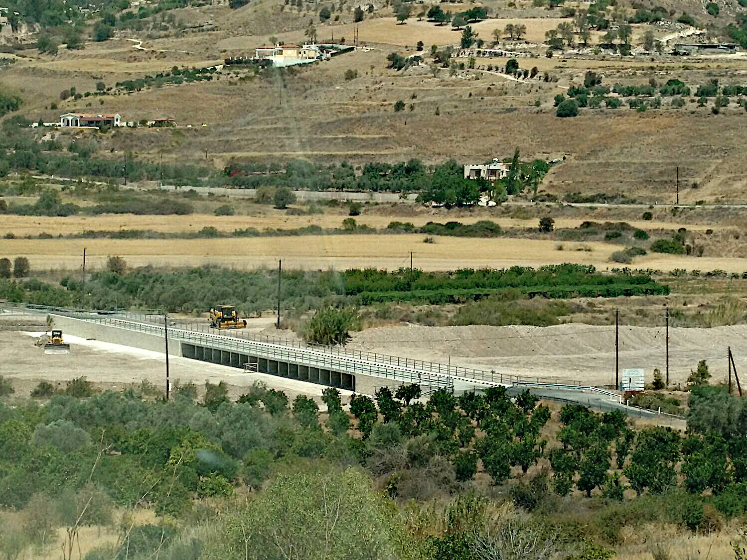 birds-eye view of highway bridge between farms